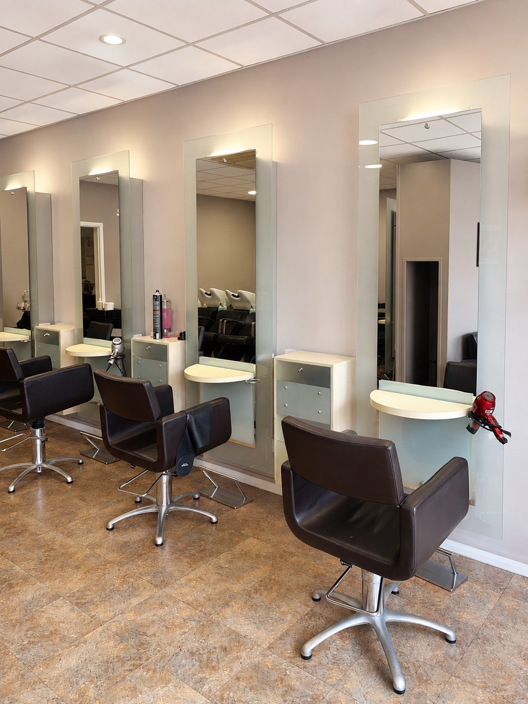 A row of styling stations with tall mirrors