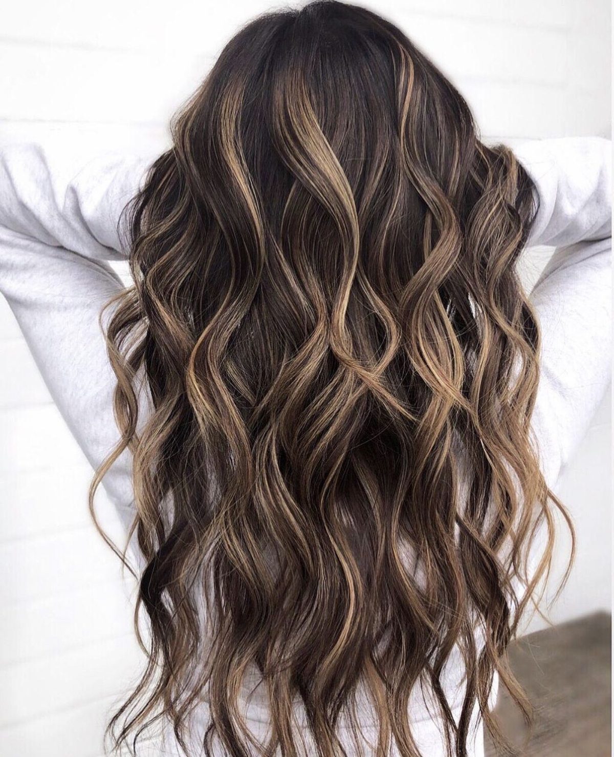 Long brunette hair with soft caramel balayage in loose waves